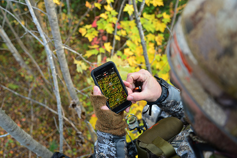 bowhunter using onX from treestand