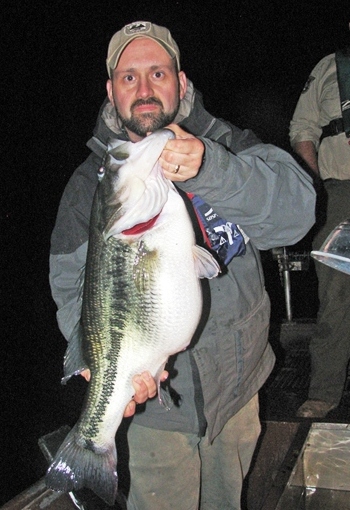 Jason Russell, eastern fisheries district technician for the Kentucky Department of Fish and Wildlife Resources, holds a giant largemouth bass captured during population sampling on 32-acre Fishpond Lake in Letcher County.
