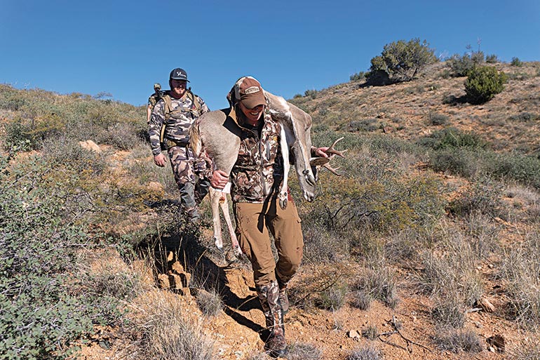 Kali Parmley carrying Coues buck