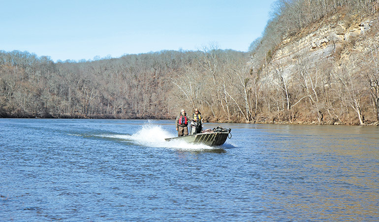 duck hunters on boat in river