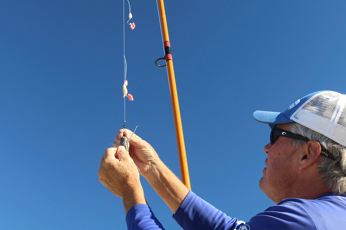 fisherman attaches sputnik weight to double dropper rig for pompano