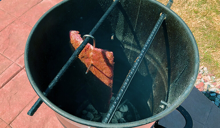 Pork ribs hanging in Pit Barrel Cooker