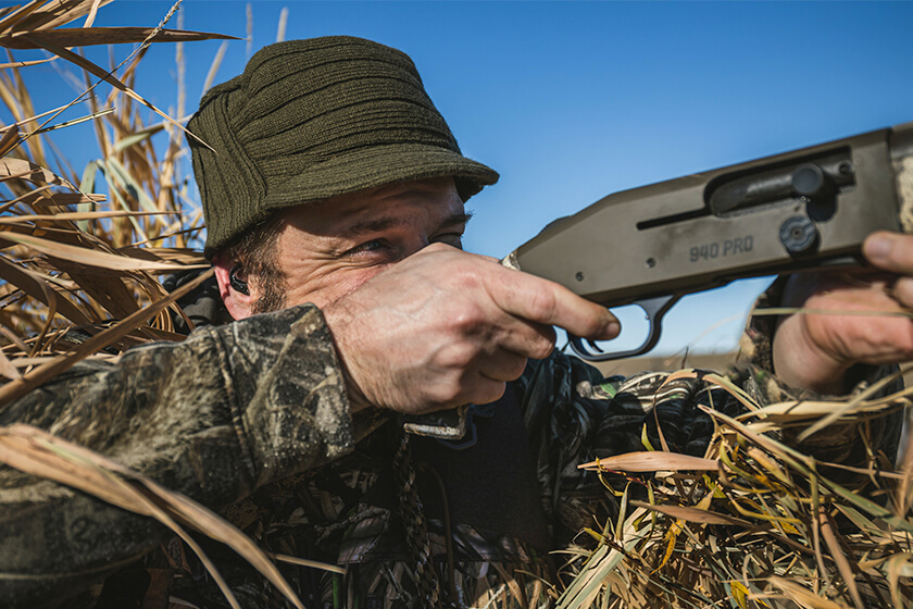 Duck hunter shooting shotgun wearing Tetra Hearing Wingshooter AlphaShields electronic hearing protection