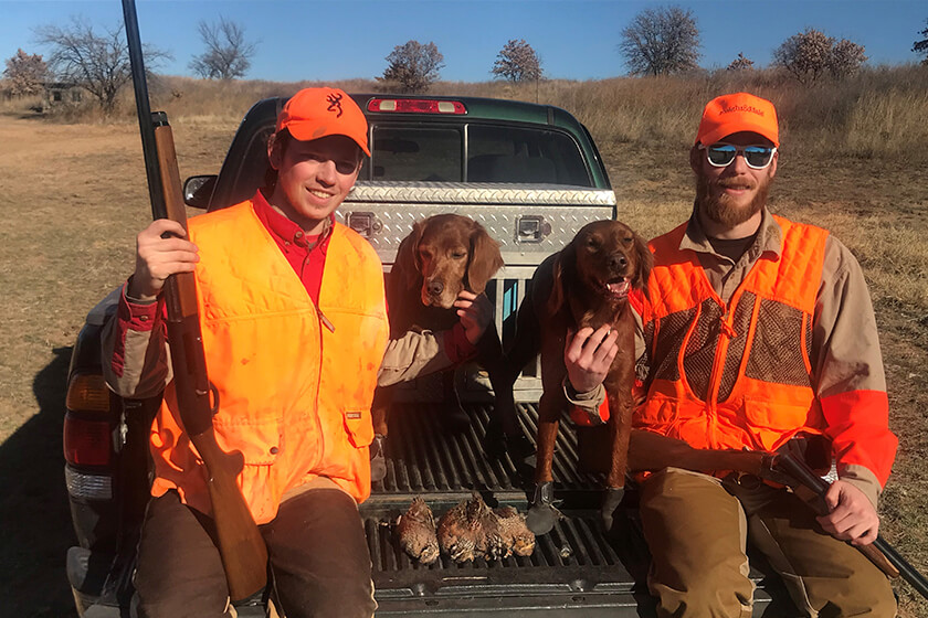 Two brothers enjoying the post-hunt with their dogs