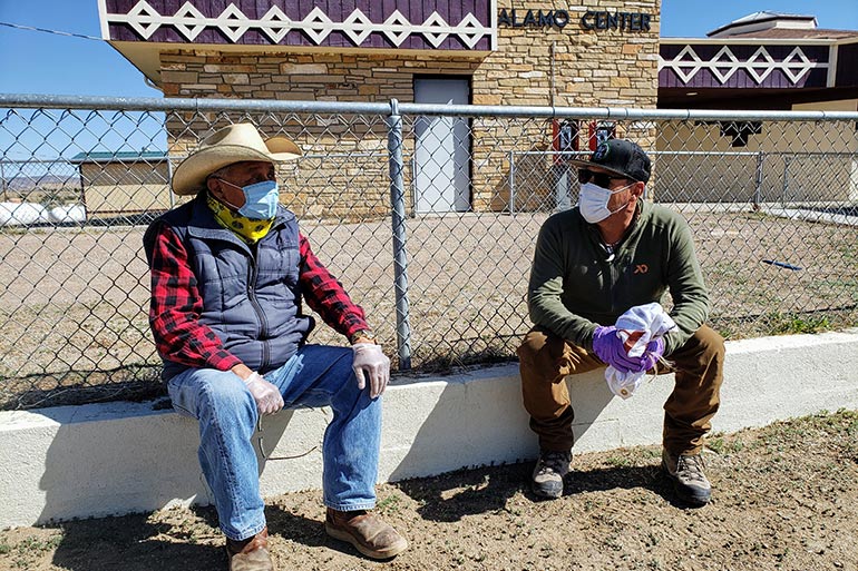 hunter and Navajo man talking while wearing masks