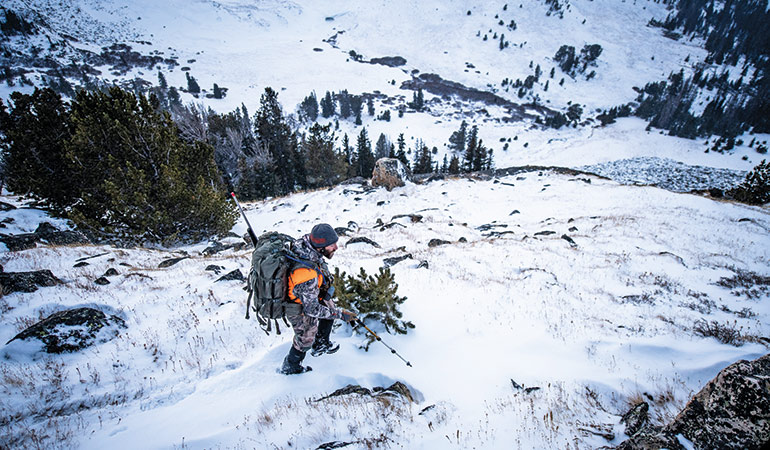 hunter trekking through snow