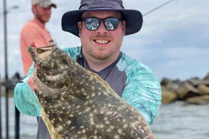 angler holds up large flounder caught off south jetty in Jacksonville Florida