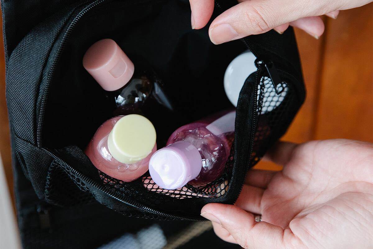 hands holding open packed toiletries bag