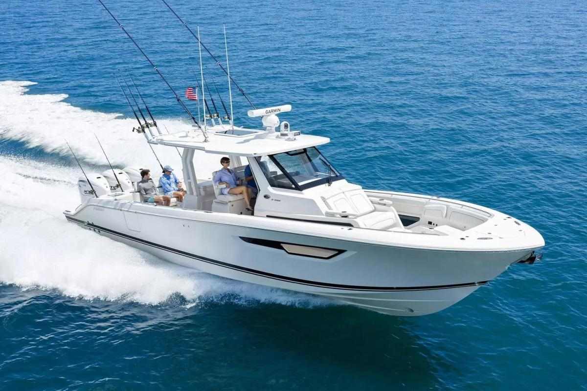 White twin engine offshore center console running with anglers seated