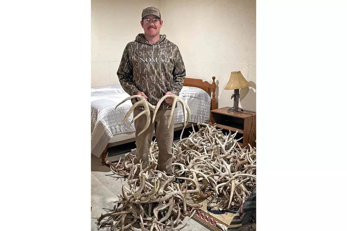 shed hunter with a pile of deer sheds around him