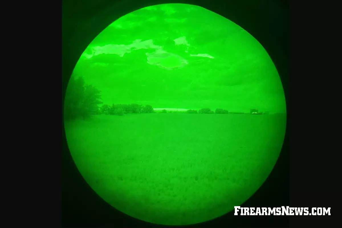 View through a PVS-14 night vision device showing a green image of a field
