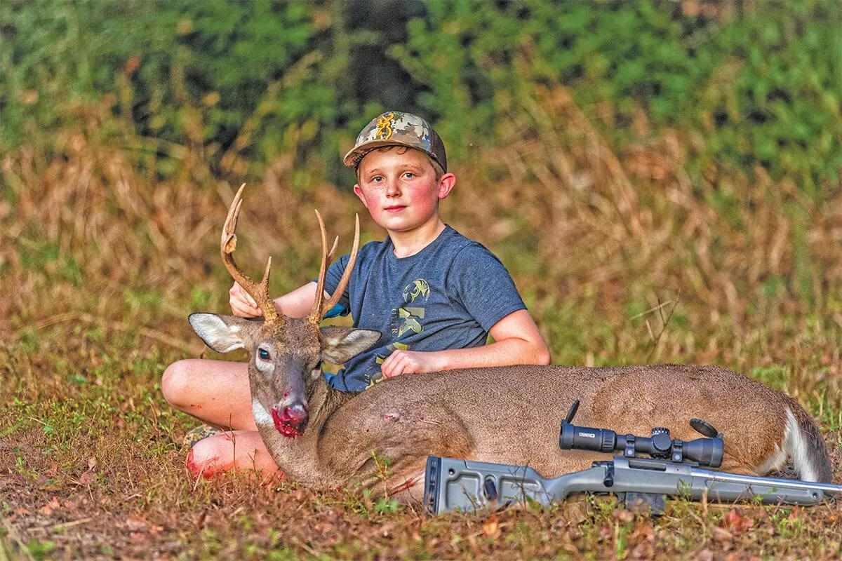 youth hunter with buck