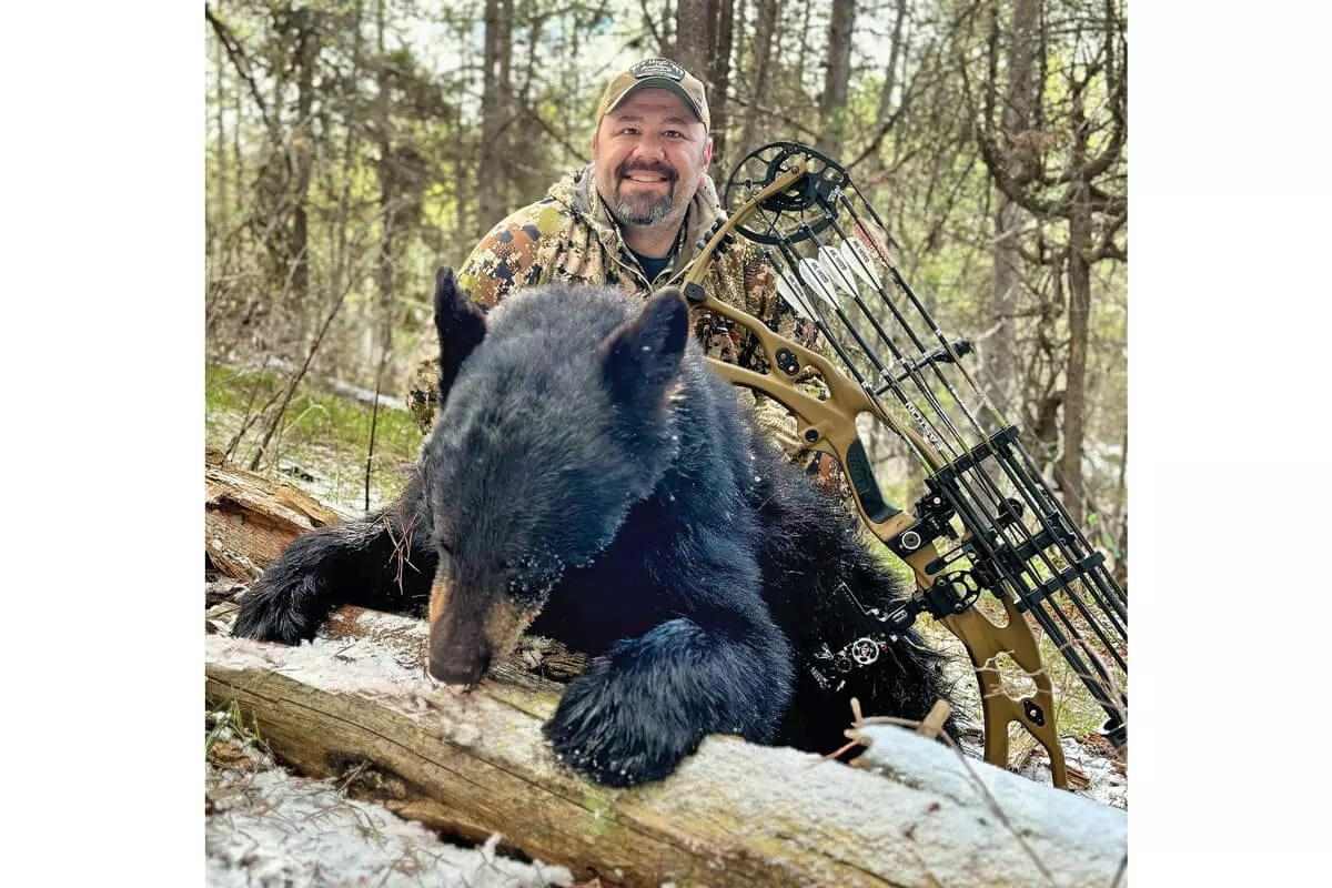 bowhunter with downed Wyoming black bear in 2024