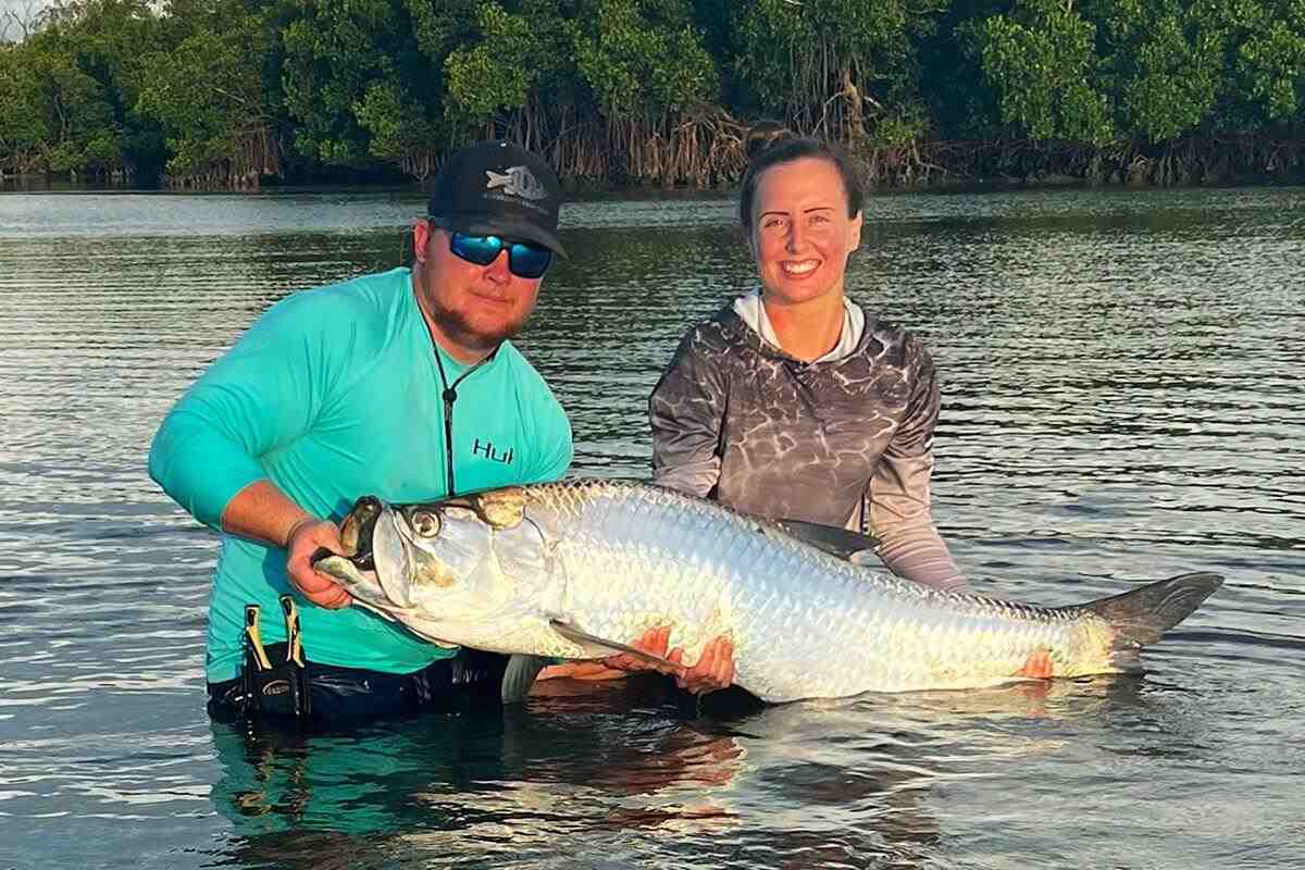 Caitlyn Gatrell and boyfriend lift up a big southwest florida tarpon