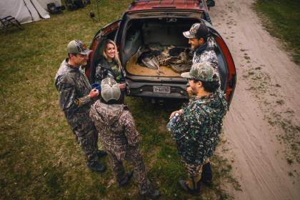 Hunters gather around the tailgate after a successful day hunting turkeys