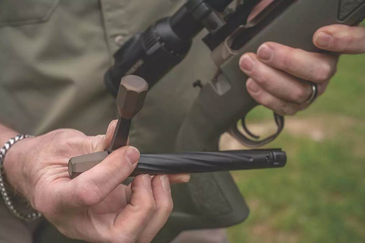 A shooter displays the removed bolt from a rifle. 
