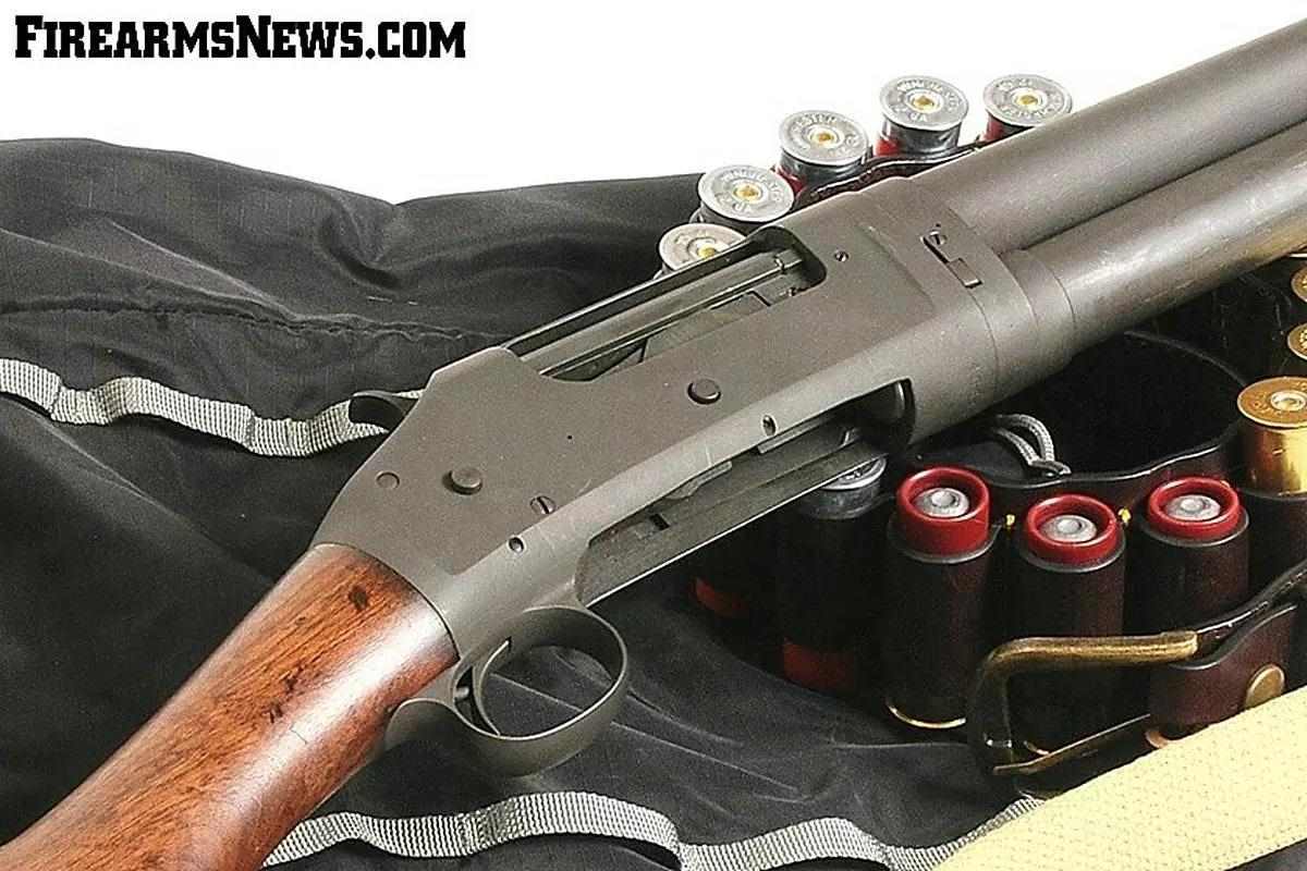 Close-up of Winchester Model 1897 shotgun’s action and leather belt holding cartridges.
