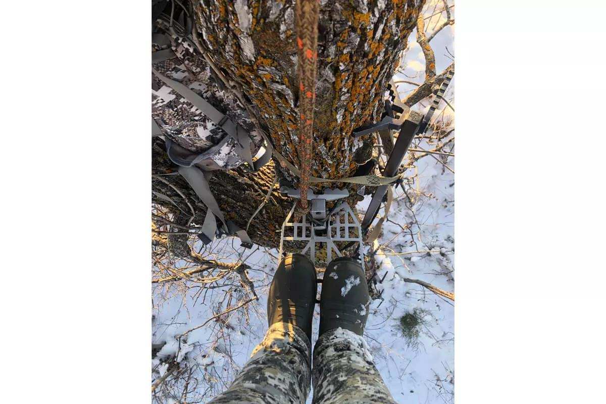 hunter in tree saddle with snow