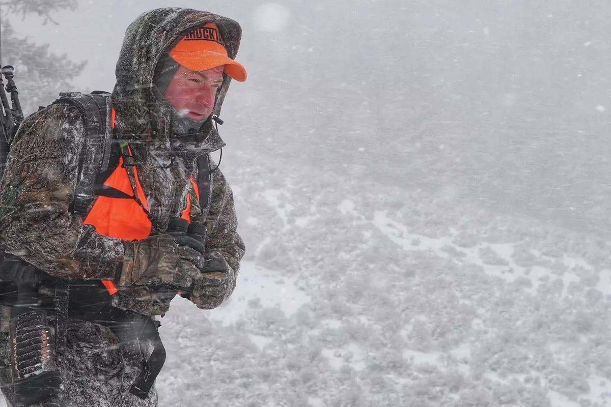 A hunter looks for game while in heavy blowing snow. 
