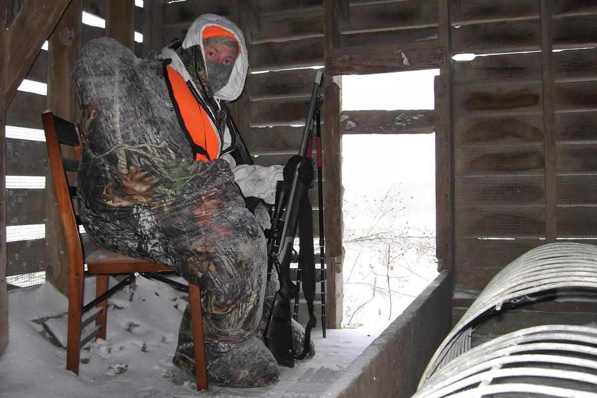A deer hunter takes refuge in an abandoned shack from the cold weather. 