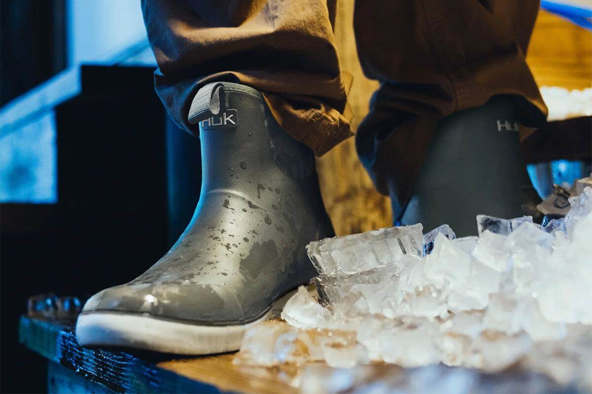 Huk Rogue Wave fishing waterproof boots on dock with ice cubes in foreground