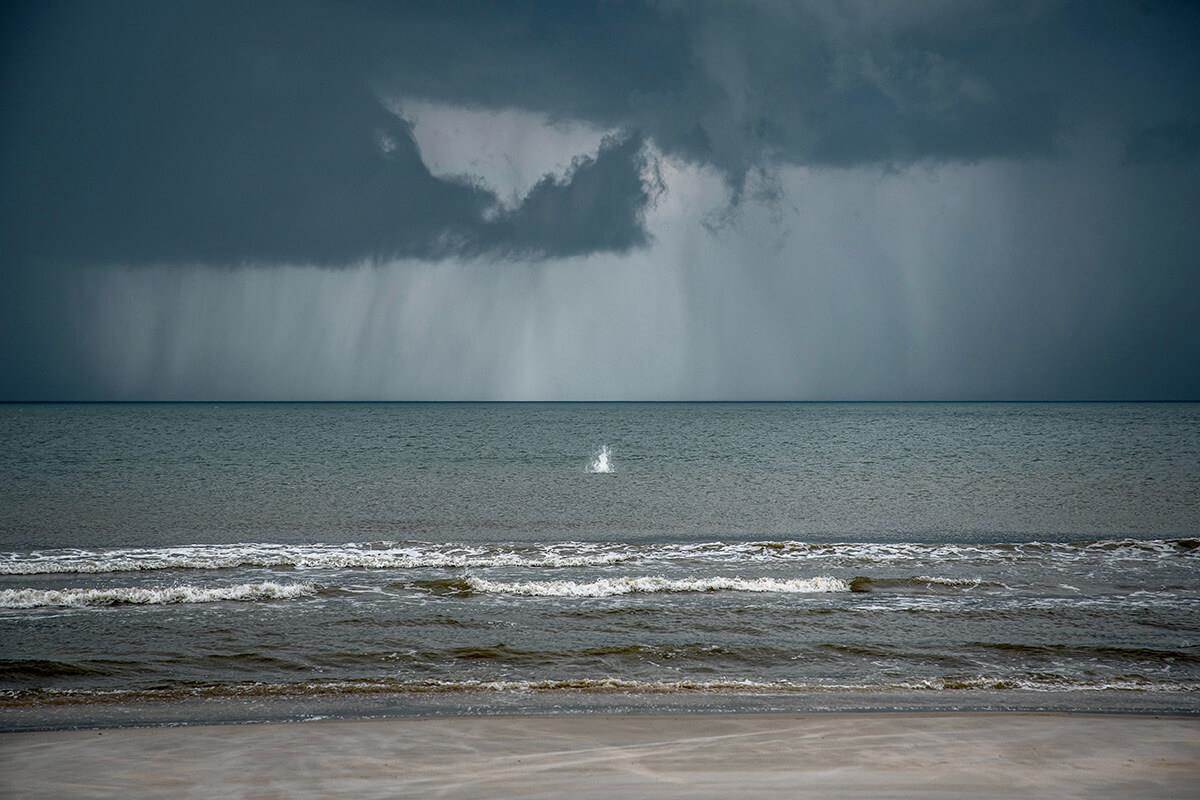 stormy weather off the beach and a splash of water in the surf