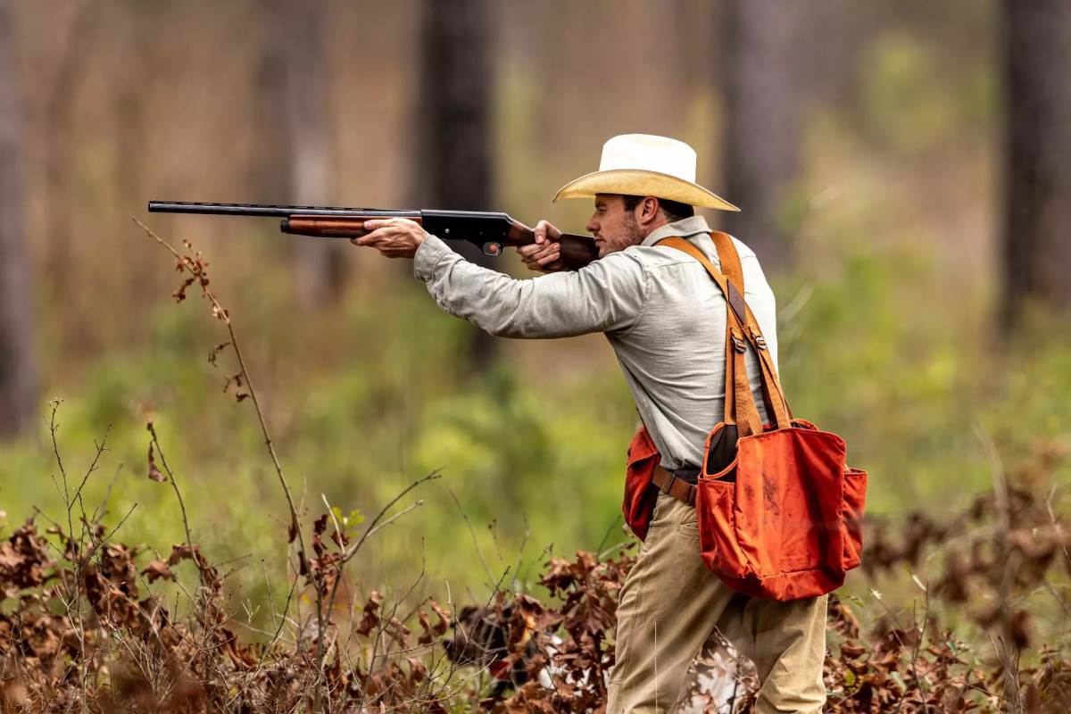 A hunter shooting in the woods.