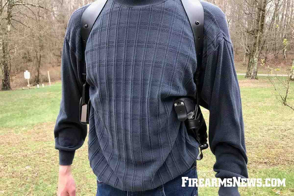 Man carrying black leather shoulder holster with gun and magazines
