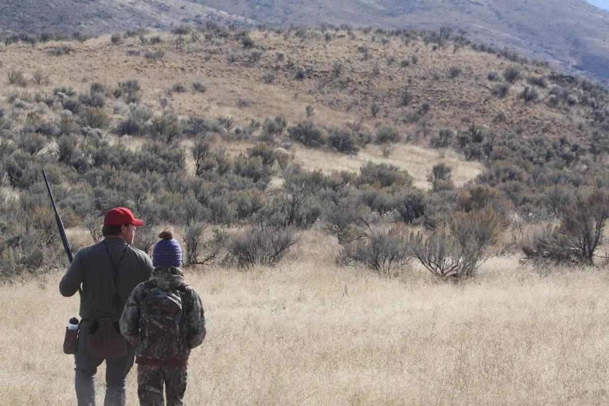 A pair of hunters walk in search of chukar to shoot. 