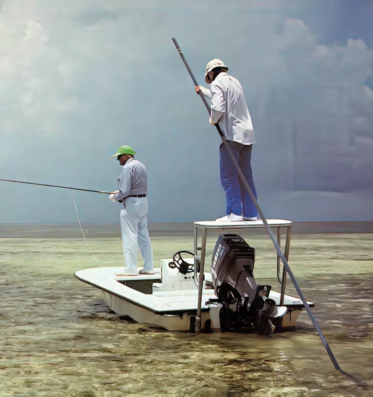A fly angler angler and guide on a flats boat fishing for bonefish.