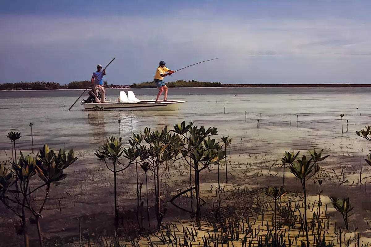 A fly angler and guide fishing from a flats boat. 