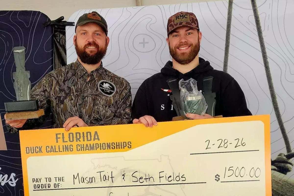 Two duck callers holding their prizes.