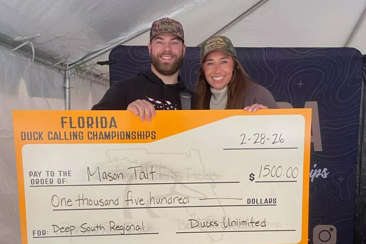 A duck hunter and his significant other with a prize.