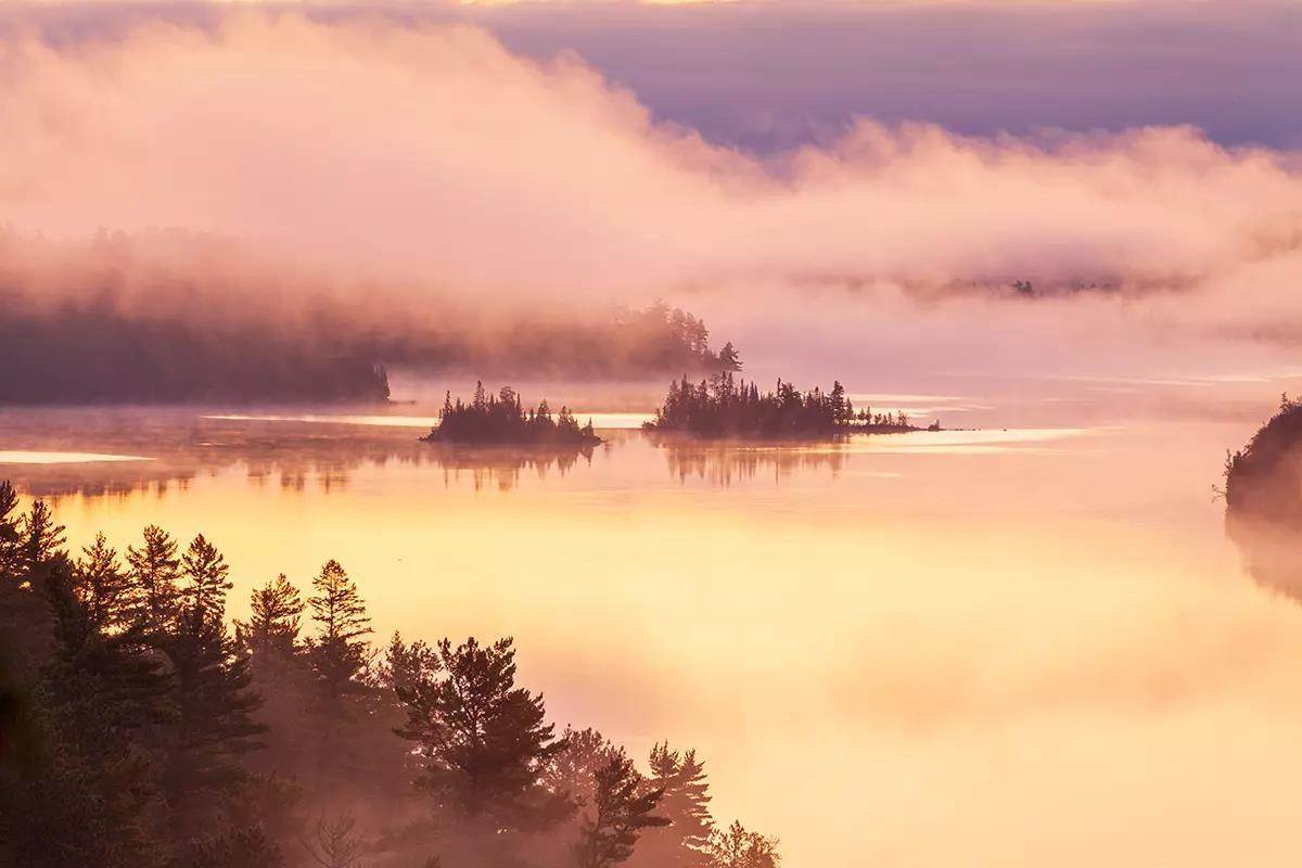 Islands in early morning fog on a Boundary Waters lake in northern Minnesota during autumn.