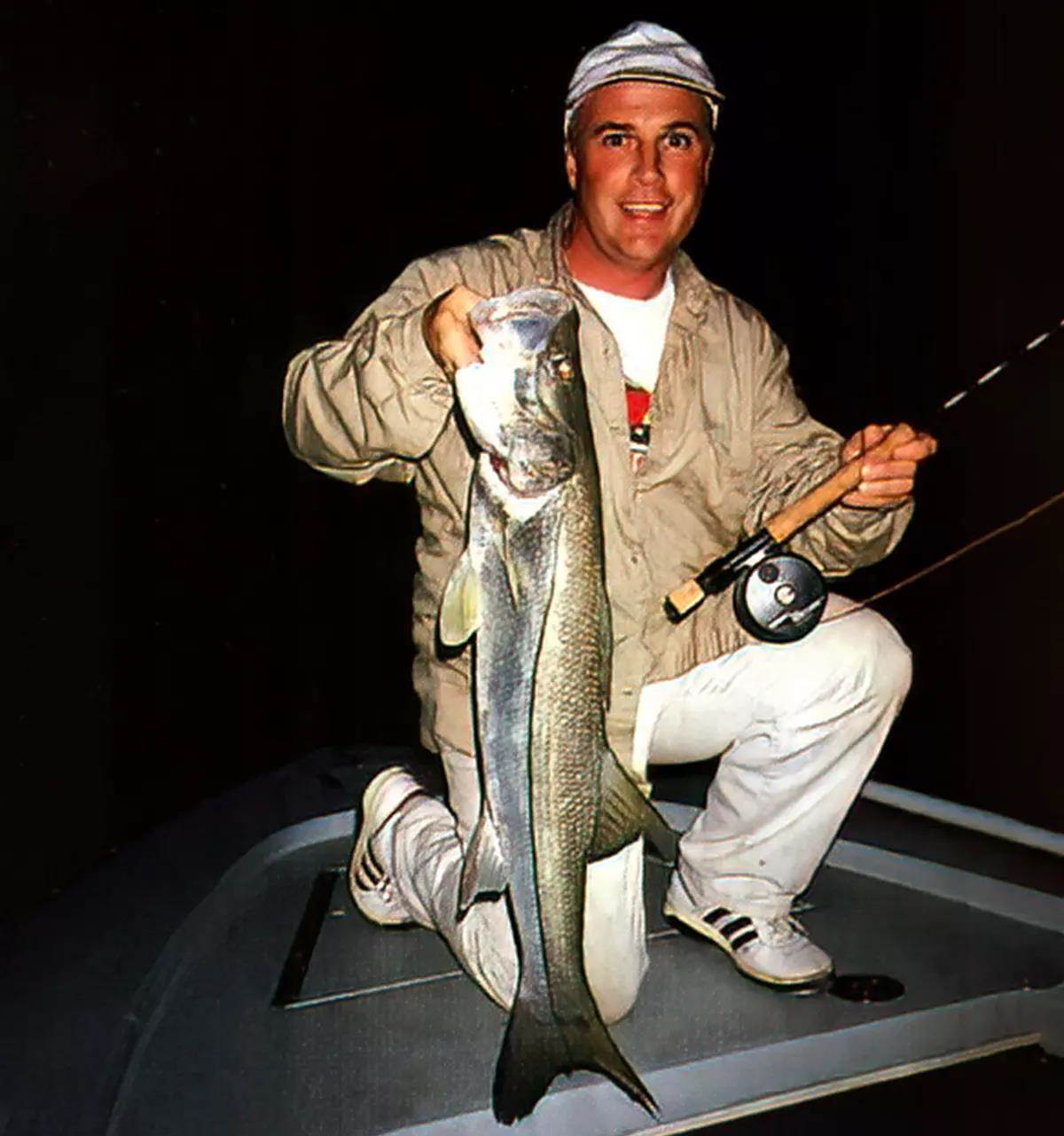 A fly angler holds a snook.