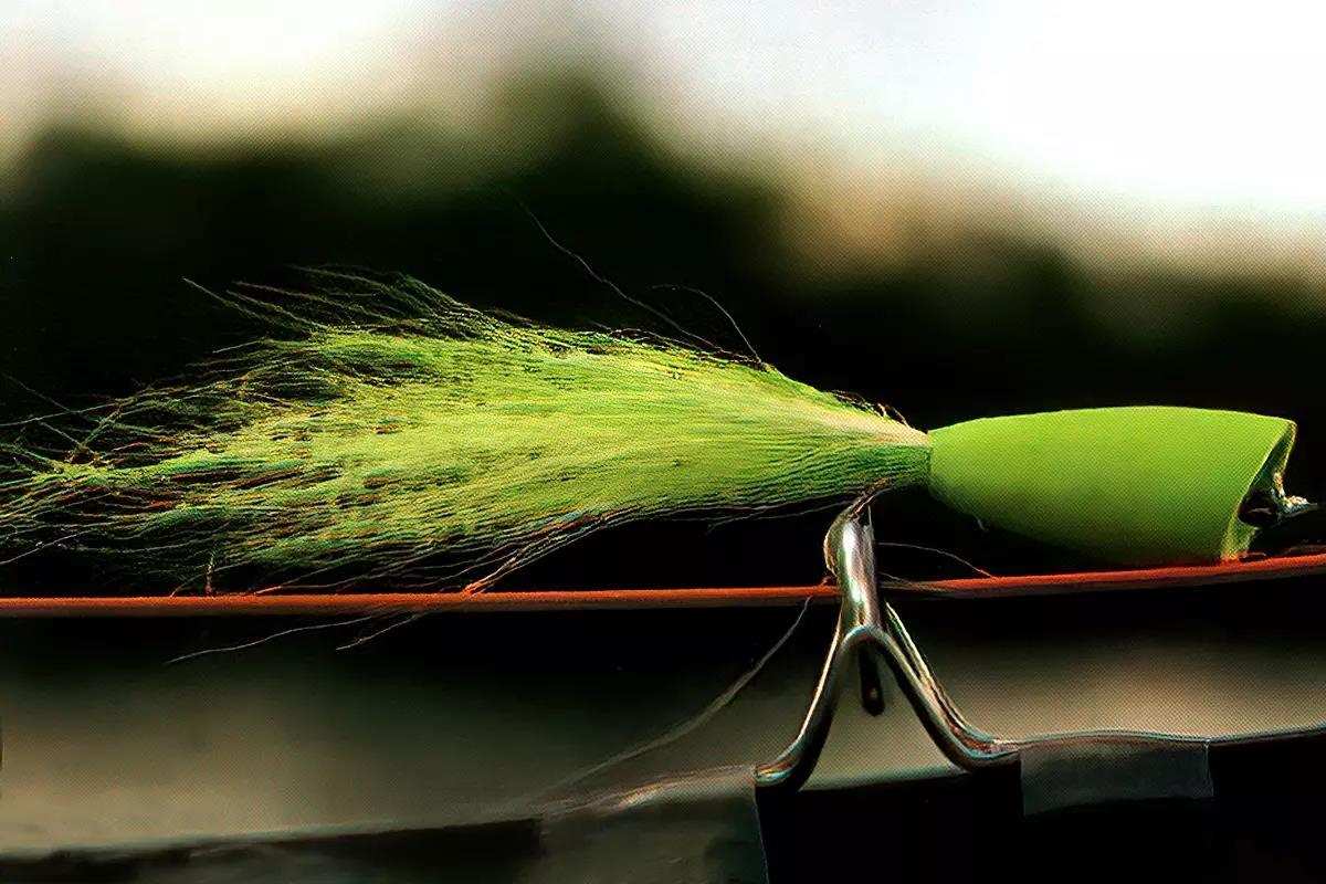 A green popper fly on a fly rod. 