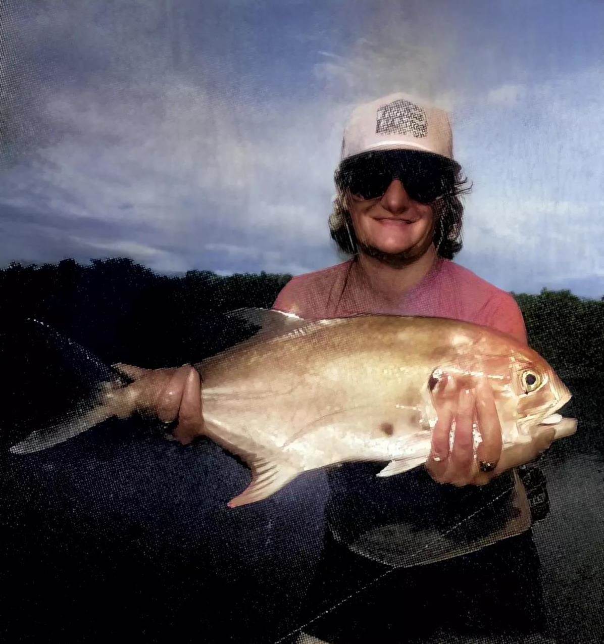 An angler holding a jack crevalle up for the camera. 