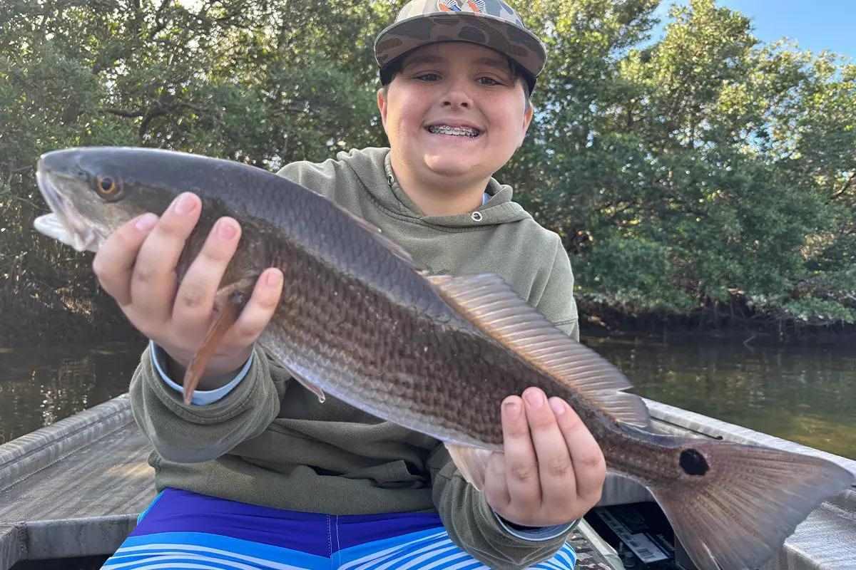 Young angler with a large redfish.