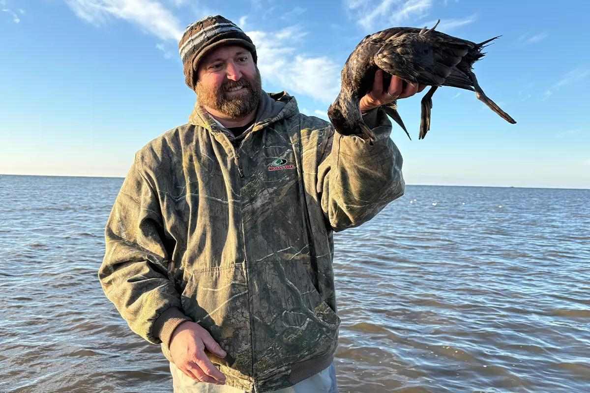 Sea duck held by hunter.