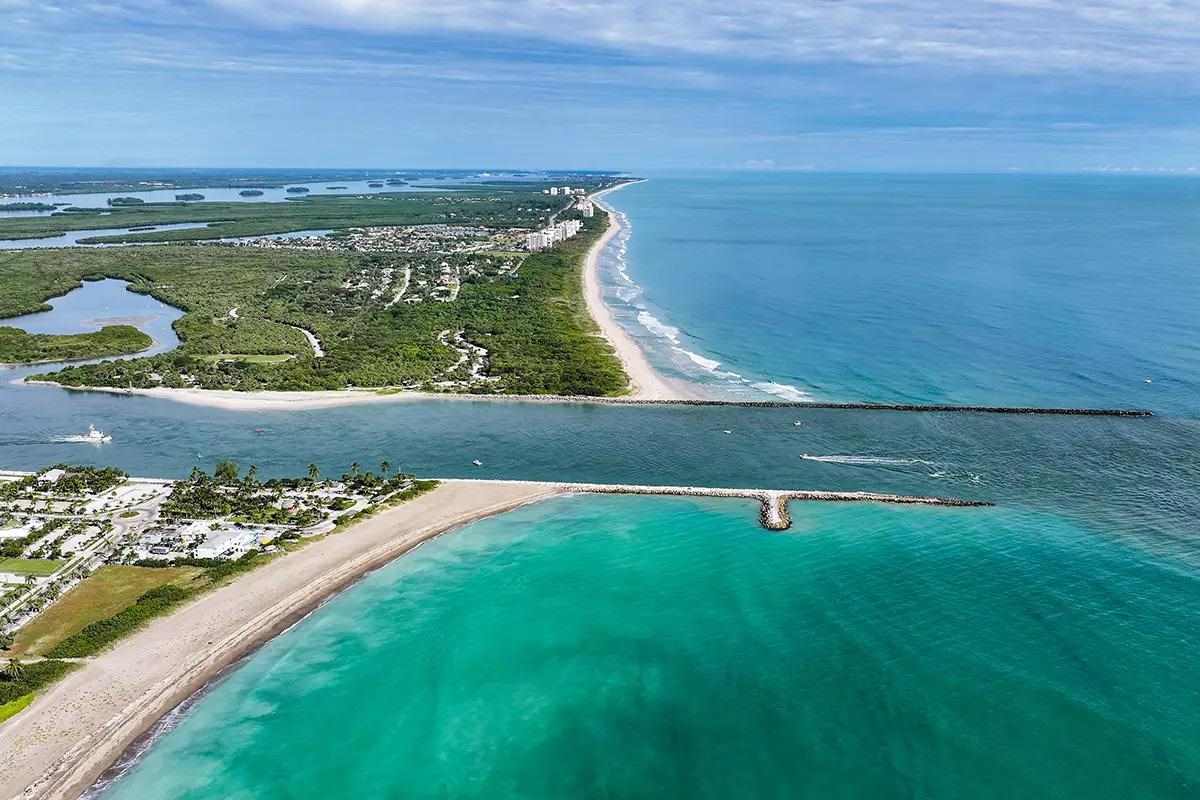 Aerial view of Fort Pierce Inlet with rock jetties and calm blue water 
