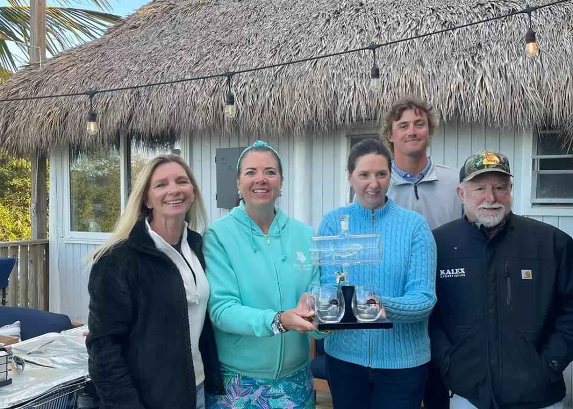 three women two men anglers holding trophy