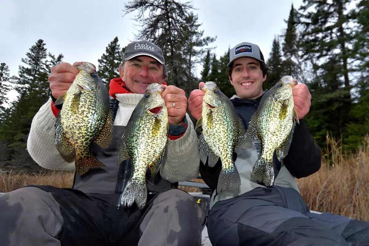 image of two men holding up crappie while out fishing