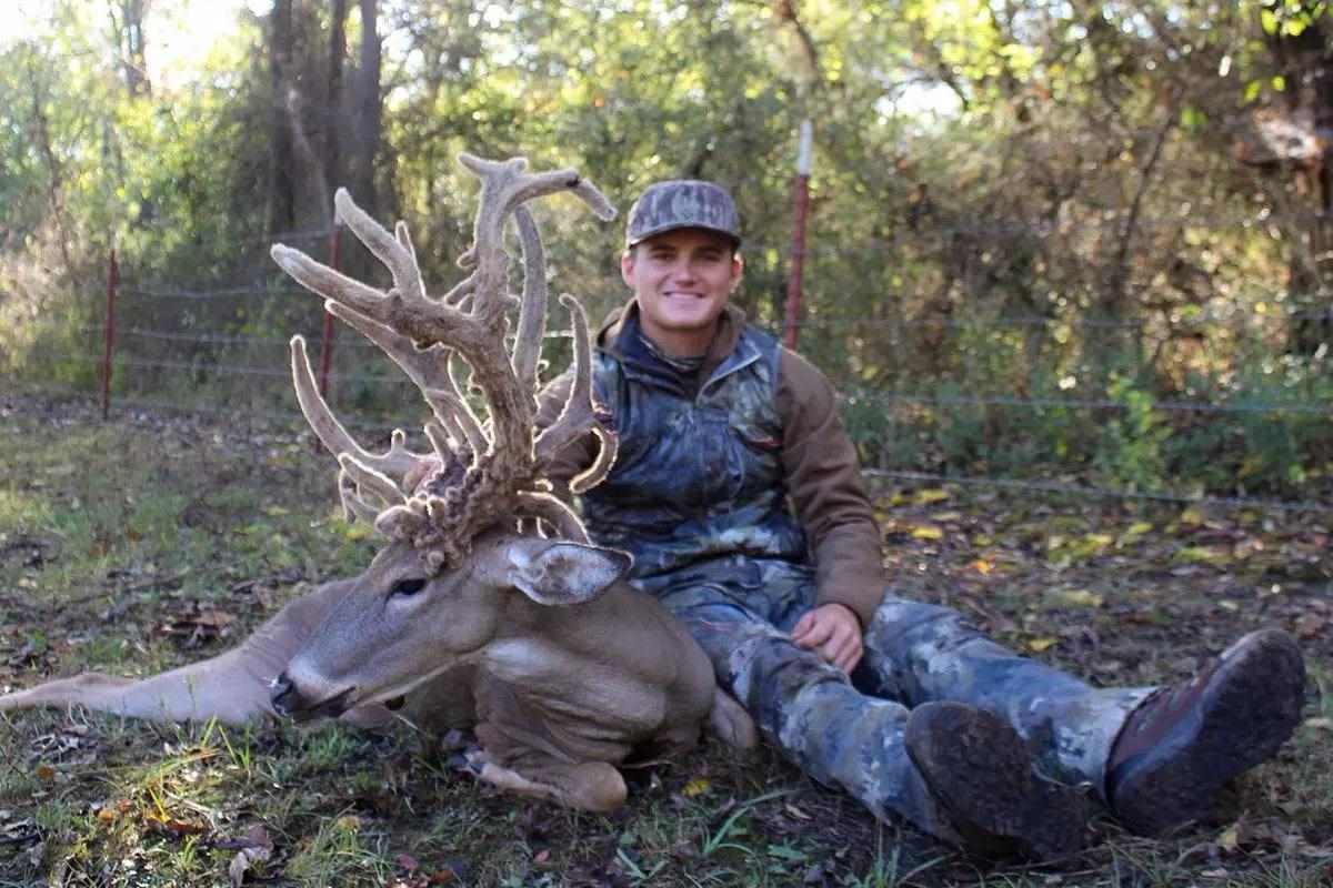 Jace posing with buck showing the bucks left side