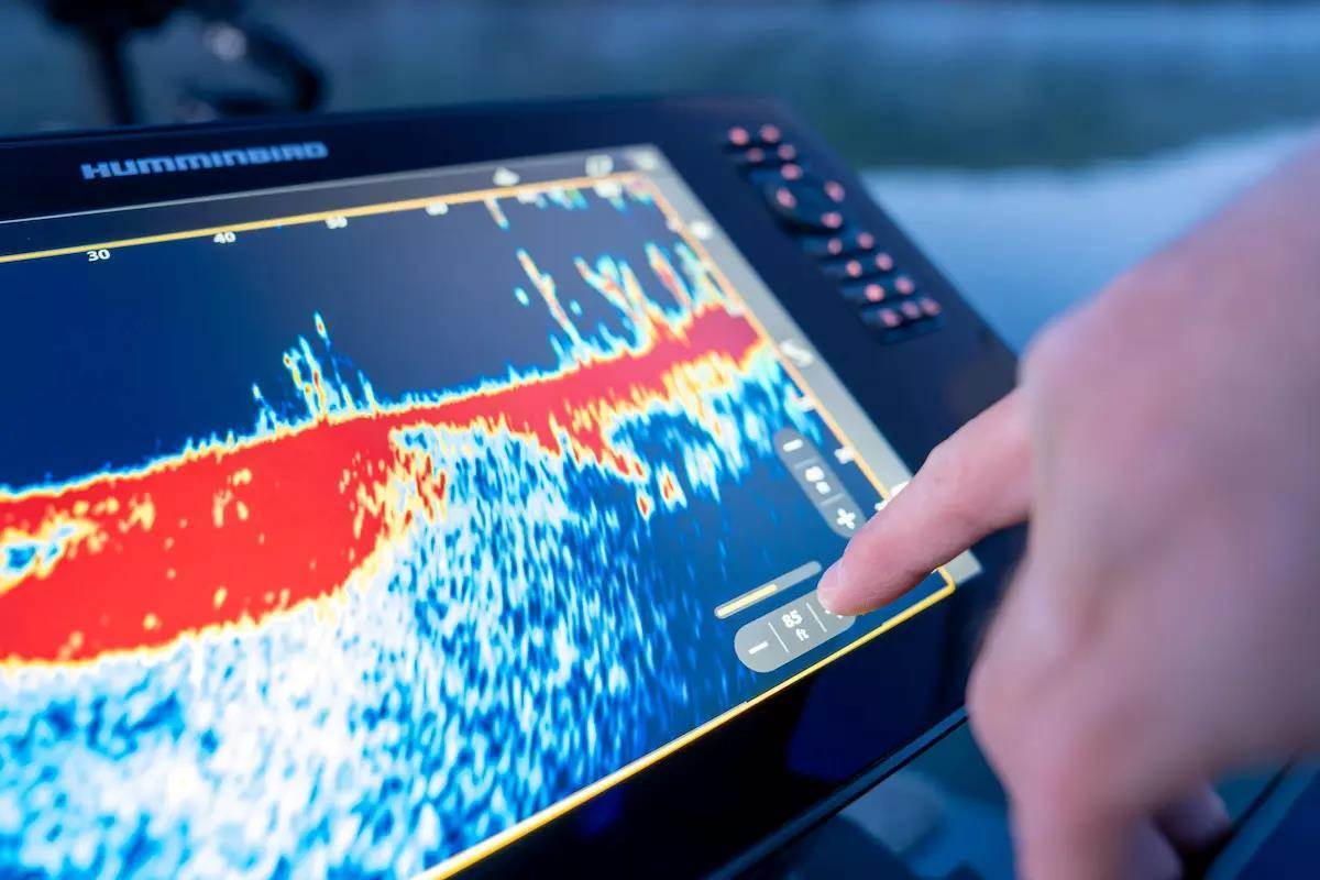 An anger uses a fishing sonar unit to find structure and fish. 
