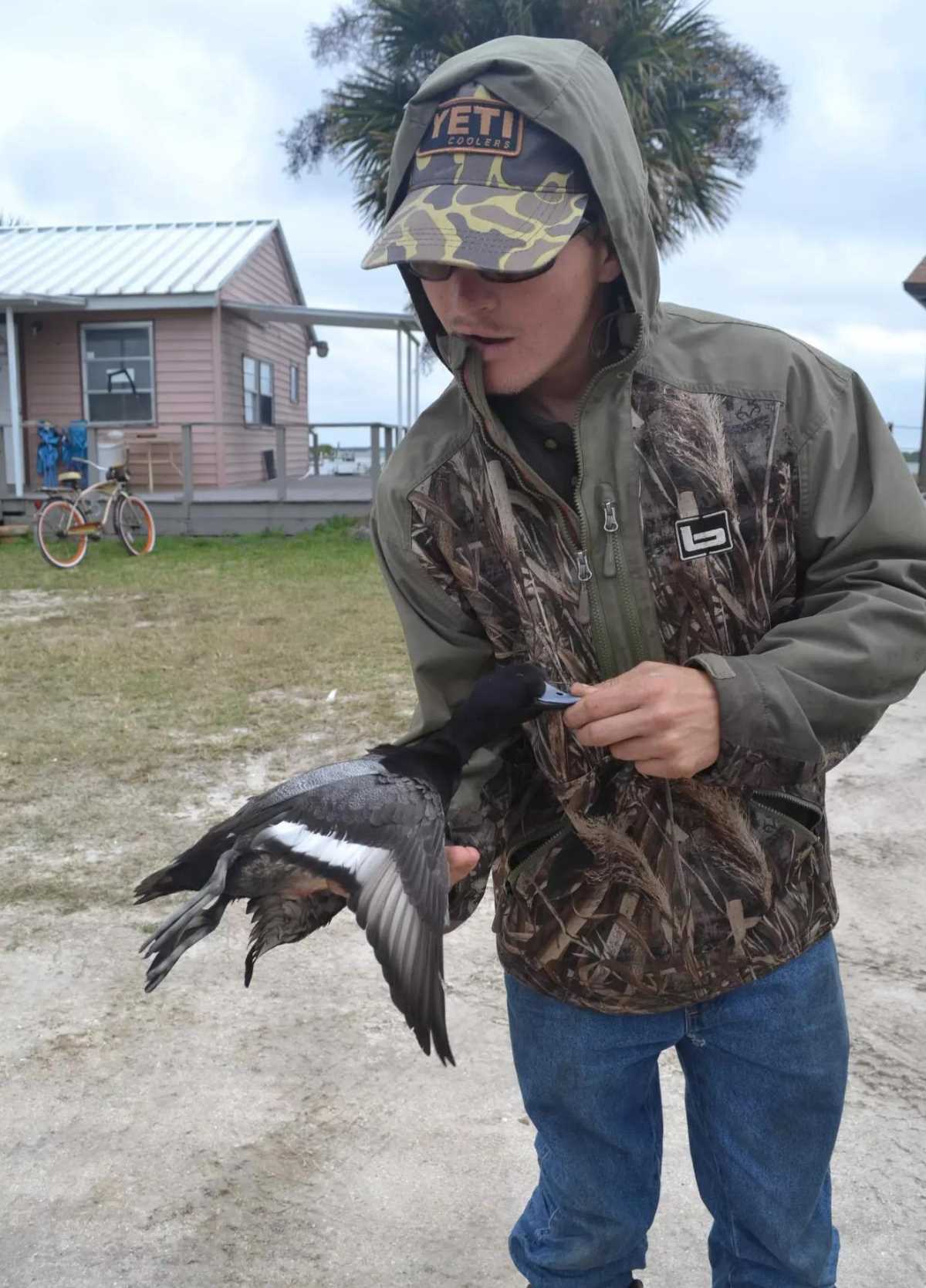 Hunter holds up a lesser scaup duck