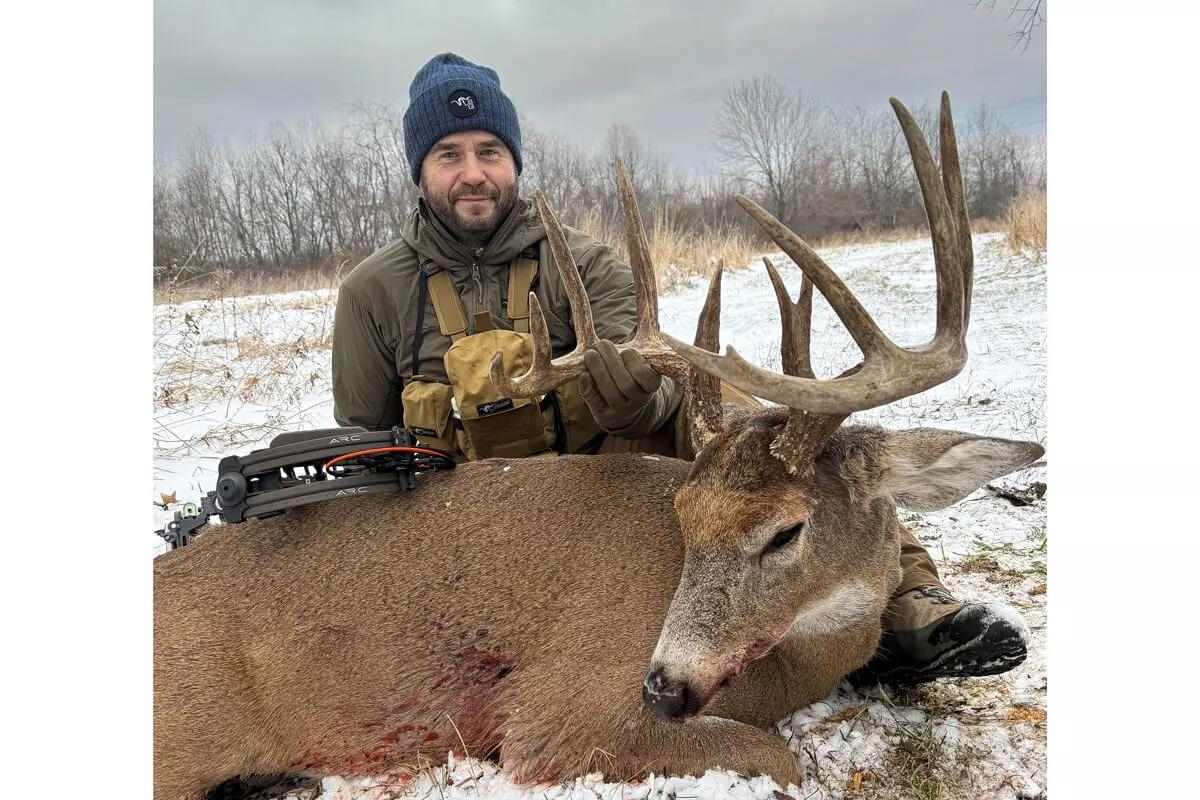 bowhunter with downed ohio whitetail buck