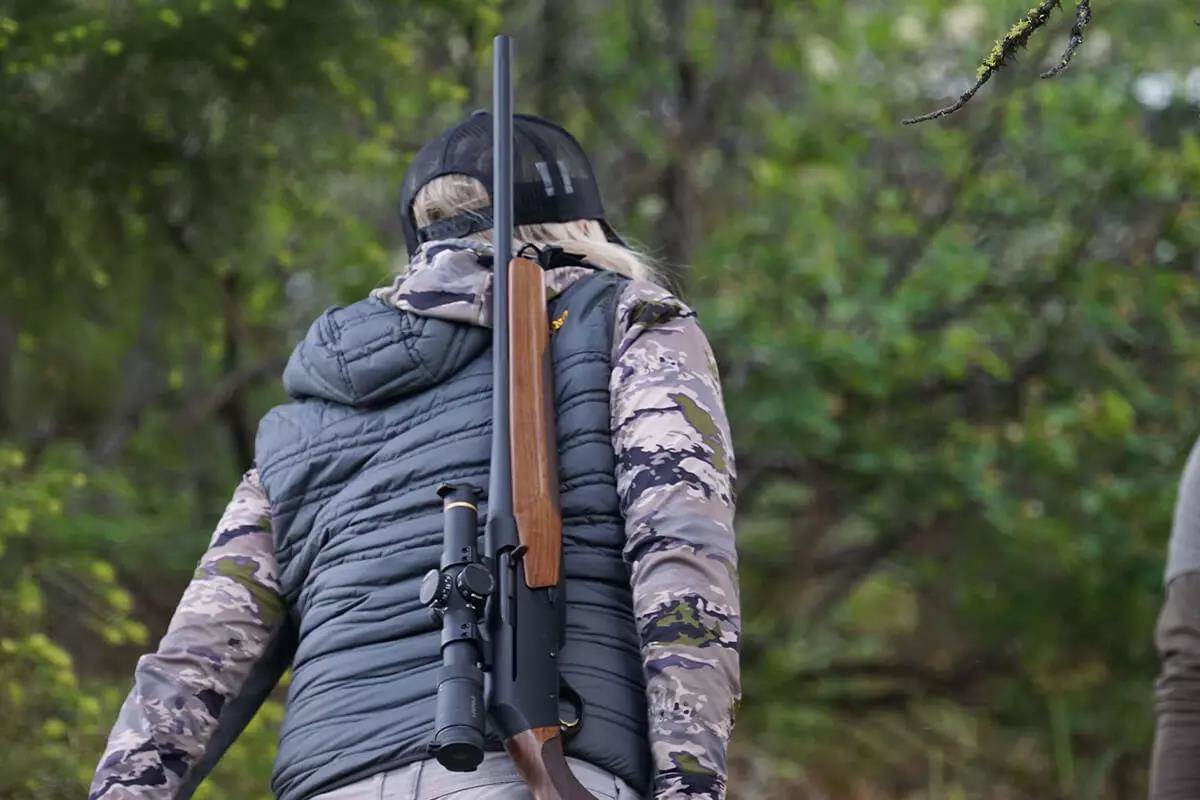 rifle slung over shoulder