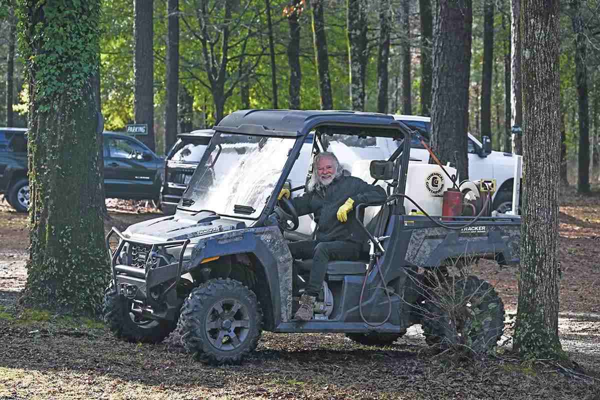 Chuck leaves drives an ATV with forestry equipment attached to it.