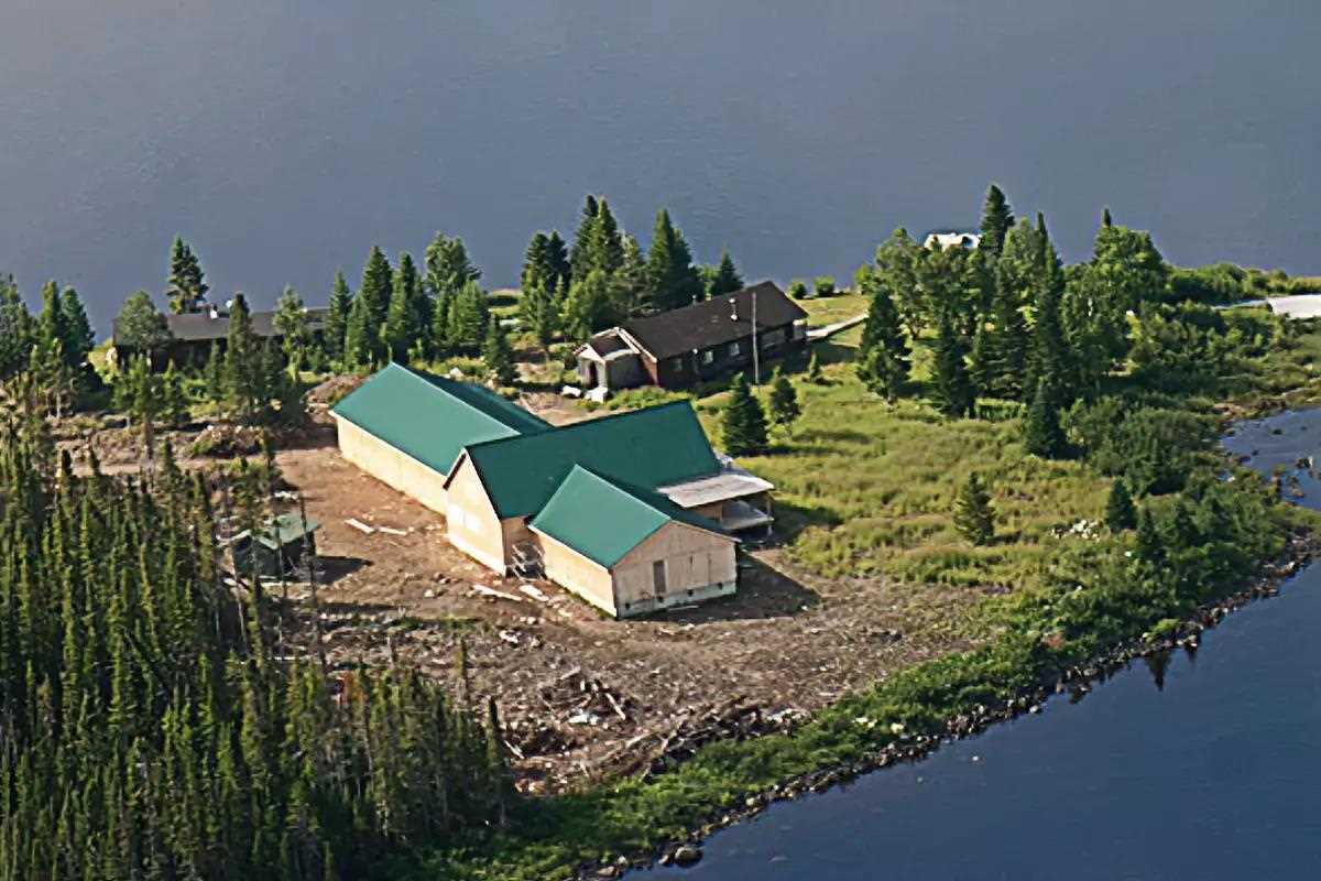 Aerial photo of a green-roofed lodge on a peninsula. 