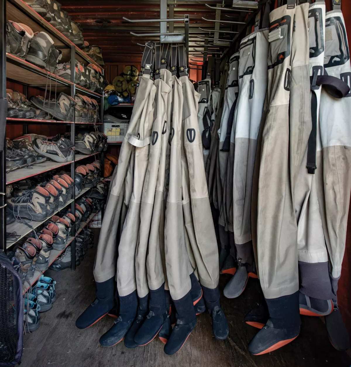 A gear locker showing many pairs of waders and boots. 